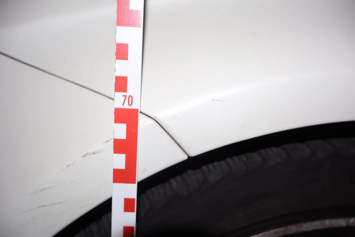 Beweissicherung mit Maßstab am weißen Kotflügel